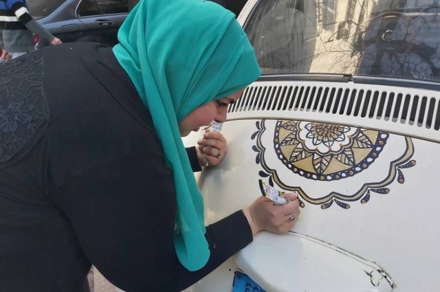 شابة مصرية تخفي خدوش السيارات بالرسم عليها