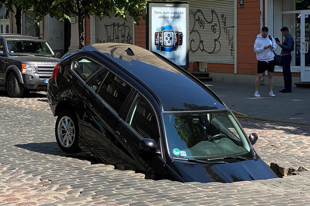 حفرة تبتلع سيارة BMW  الفئة الثالثة ومرسيدس